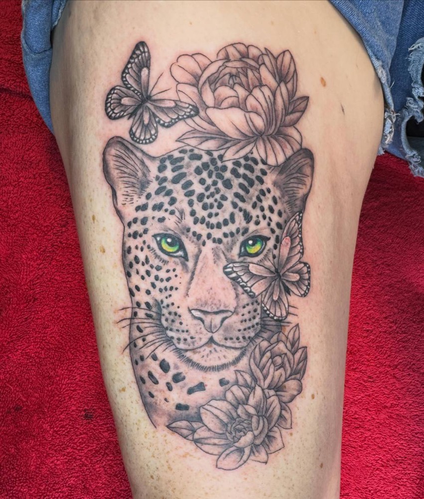 Leopard with butterflies and flowers on a thigh