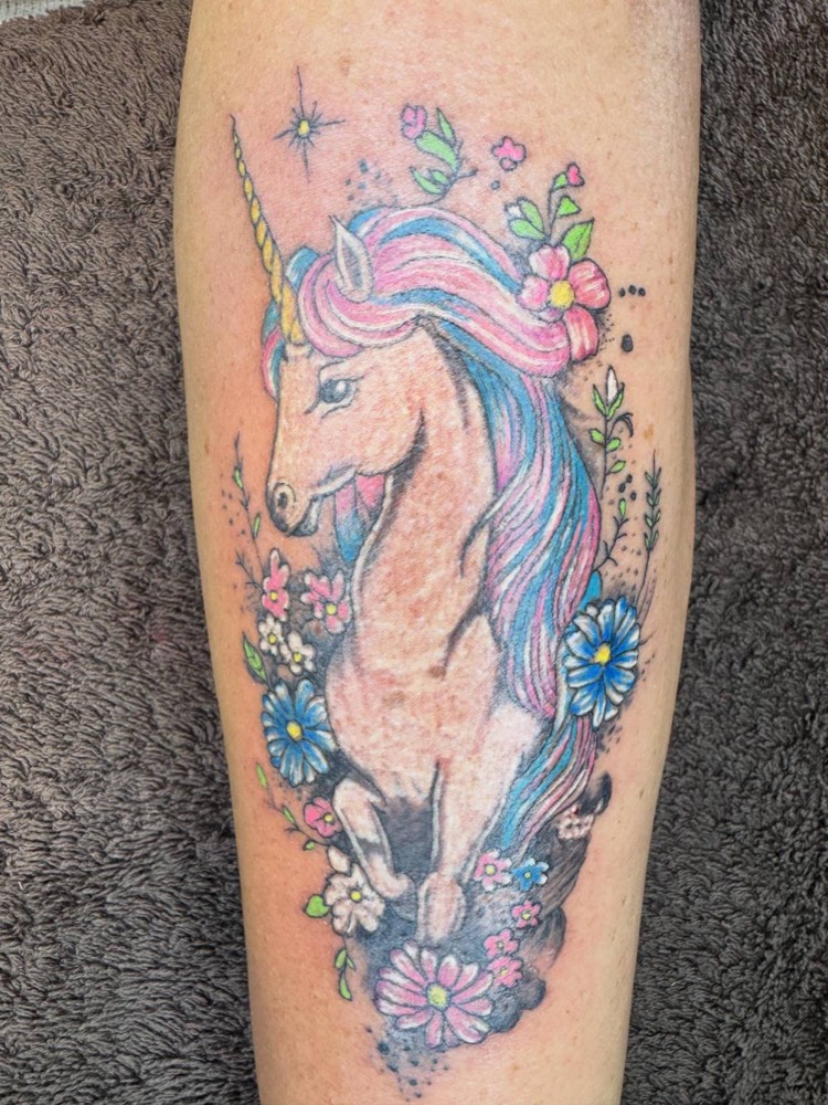 Colour unicorn with flowers on a forearm
